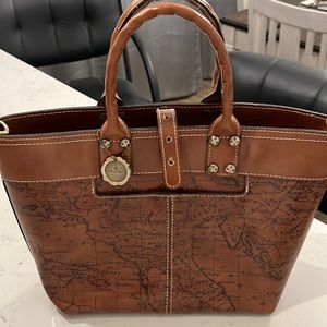 Never used, map print. Has registration card, crossbody strap and dust bag